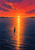 A small silhouetted sailboat crosses calm indigo water beneath a coral and magenta sunset with a bright golden reflection.