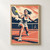 Adult woman tennis player lunging with a racket toward a yellow ball, with a net and distant opponent in a navy, cream and salmon graphic scene.; frame shown for styling only