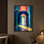 Nested blue, teal, coral, and yellow glass-like arches recede through a passage toward a pale cyan opening and distant landscape, with yellow light crossing a reflective floor.; frame shown for styling only