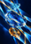 Three vertically arranged faceted glass-like forms in pale cyan, blue, and amber are crossed by luminous diagonal ribbons on a deep navy background.