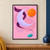 Pale-lilac crescent and floating orange disc with a looping plum ribbon and small turquoise oval on a soft-pink background.; frame shown for styling only
