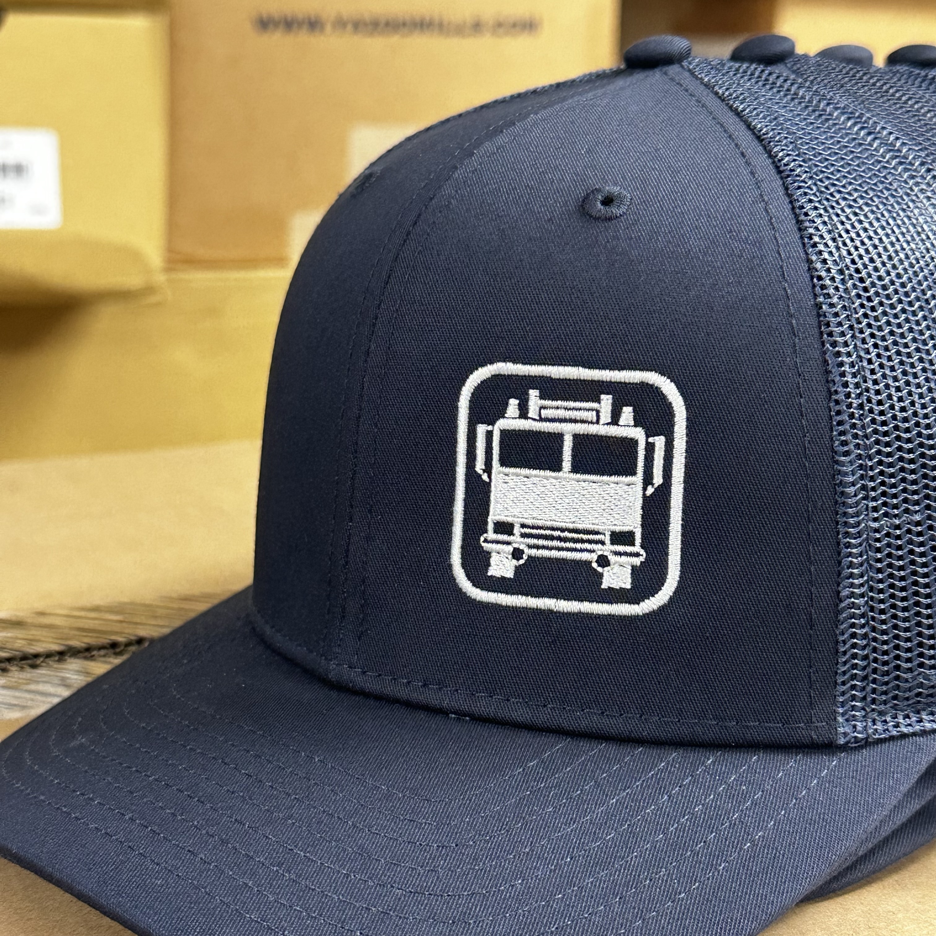 Embroidered firetruck design on left panel of navy Richardson 112 hat.