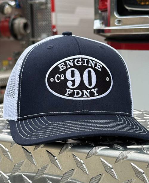 Embroidered ball cap: "Engine Co. 90 FDNY," resting on diamond plate