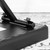 Close-up of Tiger keyboard bench adjustment mechanism, black metal frame with tightening knob attached beneath padded seat.