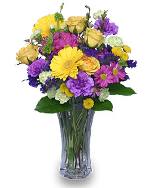 8 1/2" flared rose vase
foliage: salal, leather leaf
4 yellow roses
2 yellow gerberas
2 stems fuchsia daisy poms
3 stems purple 'Sinuata' statice
3 stems apple-green mini carnations
4 purple 'Moonshade' carnations
2 stems yellow button poms