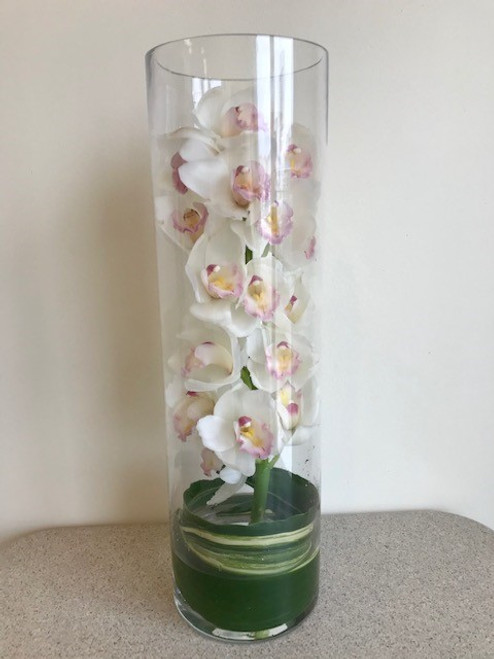 Beautiful 20 inch cylinder vase, with large stem of white cymbidium orchid and a aspidistra leaf
