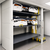 Hospital bed storage lift system with stacked medical beds in a healthcare equipment storage room