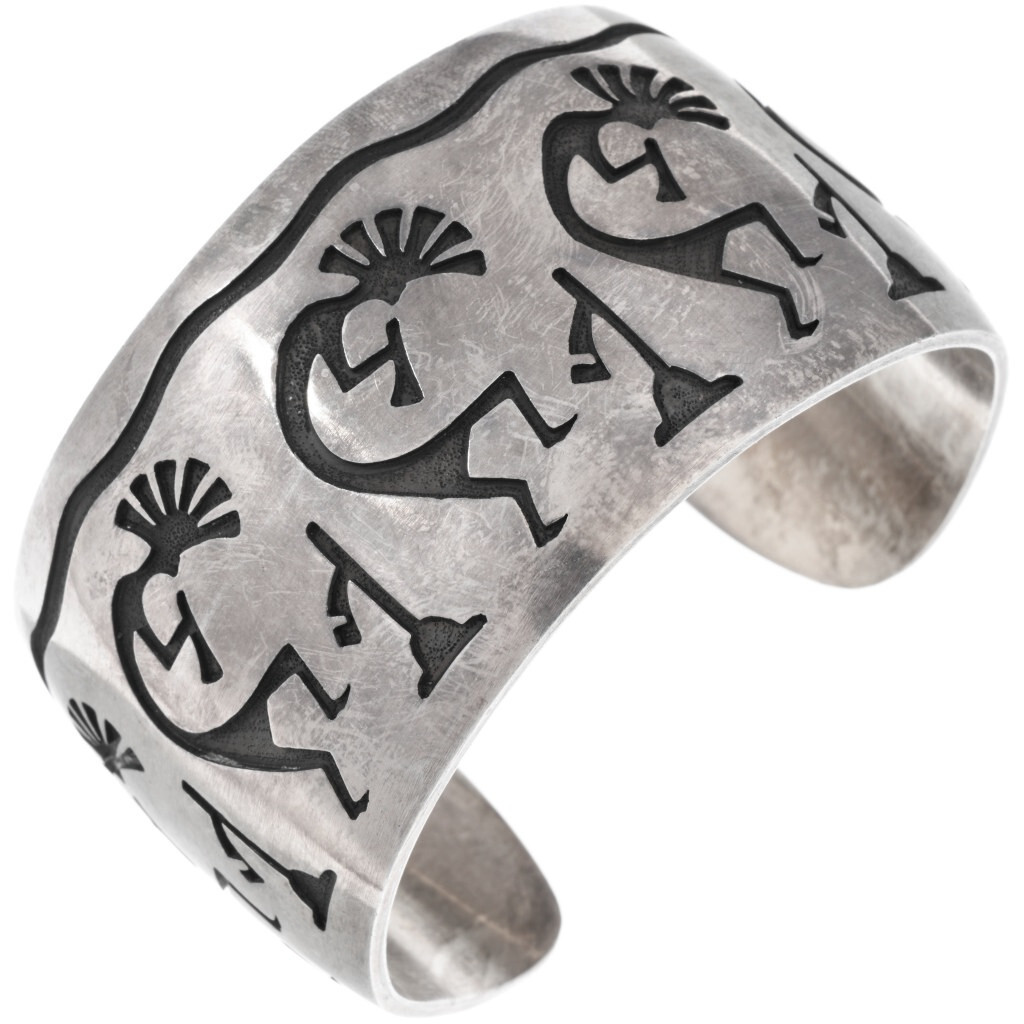 With its lively procession of Kokopelli figures, this vintage Hopi overlay cuff showcases the enduring influence of Southwestern cultural imagery on Native American silverwork