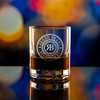 Wholesale engraved 7.75 oz. Nob Hill glass customized with Ragged Branch Distillers logo on a bokeh background