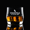Wholesale engraved Scirocco Rocks Glass customized with Thistle Finch Distilling logo on a black background