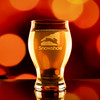 Wholesale engraved 16 oz. Barlow Pilsner Glass customized with Snowshoe Resorts logo on a bokeh background