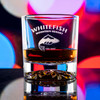 Wholesale engraved 10.5 oz. Snowflake Rocks Glass customized with Whitefish Mountain Resort logo on a bokeh background