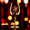 Wholesale engraved 15 oz. Stolzle Weinland Wine Glass customized with The Stanley Chocolate Factory logo on a bokeh background