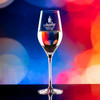 Wholesale engraved 9 oz. Stolzle Exquisit Champagne Flute Glass customized with Stanley Chocolate Factory logo on a bokeh background