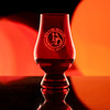 Wholesale engraved Red Glencairn blind tasting glass customized with Devils Due Distillery logo on a bokeh background