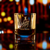 Wholesale engraved 9 oz. Prism Rocks Glass customized with Whistling Andy Distillers logo on a bokeh background