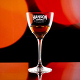 Wholesale engraved 5.25 oz. Nick & Nora Glass customized with Hanson Distillers logo on a bokeh background