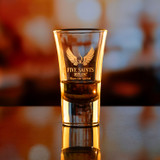 Wholesale engraved 2 oz. Moon Shot Glass customized with Five Saints Distilling logo on a bokeh background