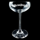 Wholesale engraved 7.75 oz. Stolzle Coupe Glass customized with Hilton Heads logo on a black background