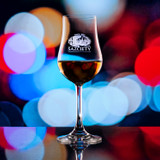 Wholesale engraved 6.25oz Stolzle Euro Tasting Glass customized with Sazciety logo on a bokeh background