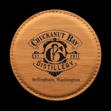 Wholesale engraved Golden Wheat Round Coaster customized with Chuckanut Bay Distillery logo on a black background
