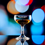 Wholesale engraved 5.5 oz. Mini Coupe customized with William Price Distilling logo on a bokeh background