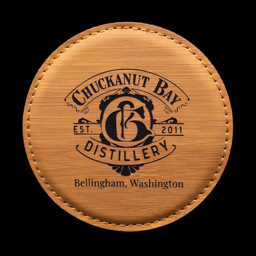 Wholesale engraved Golden Wheat Round Coaster customized with Chuckanut Bay Distillery logo on a black background