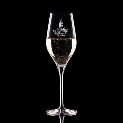 Wholesale engraved 9 oz. Stolzle Exquisit Champagne Flute Glass customized with Stanley Chocolate Factory logo on a black background