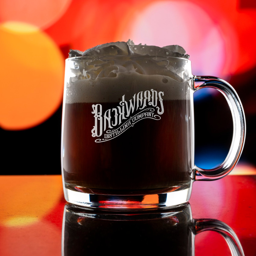 Wholesale engraved Nordic Whisky Glass Mug customized with Backwards Distillers logo on a bokeh background