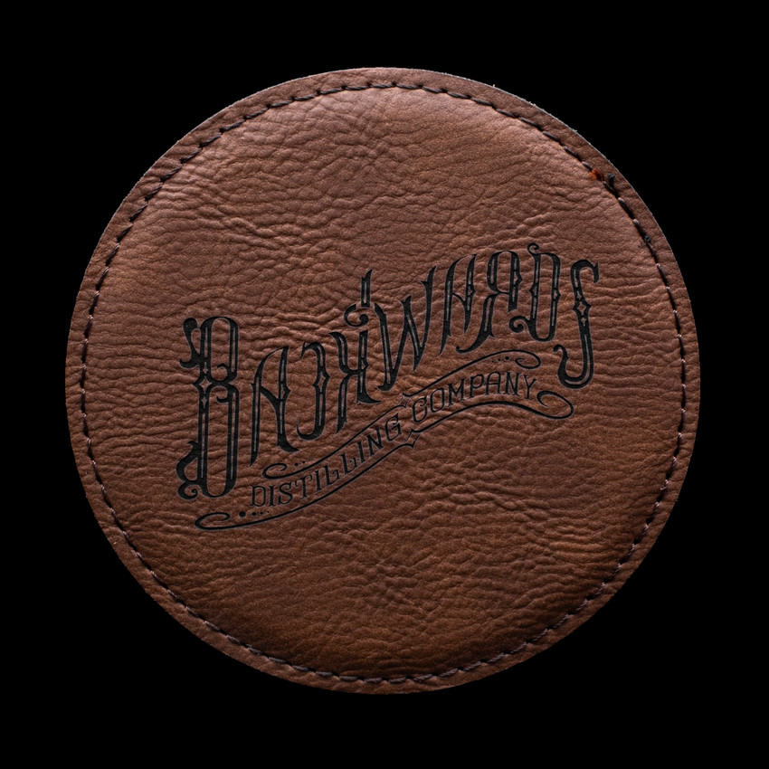 Wholesale engraved Rum Round Coaster customized with Backwards Distilling logo on a black background