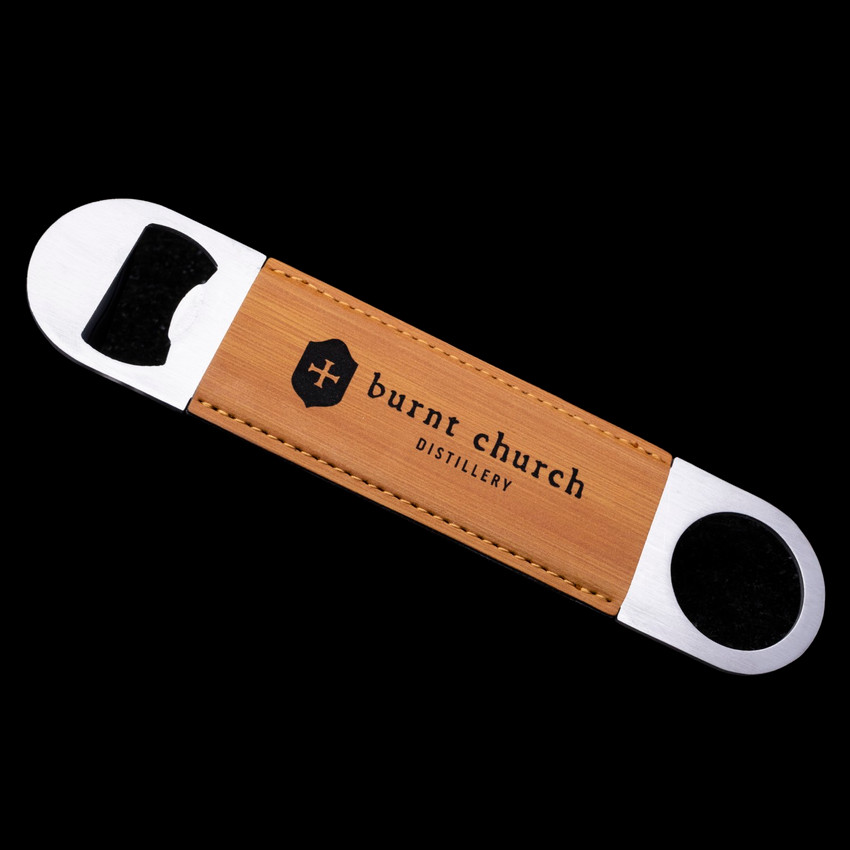 Wholesale engraved Golden Wheat Bottle Opener customized with Burnt Church Distilling logo on a black background