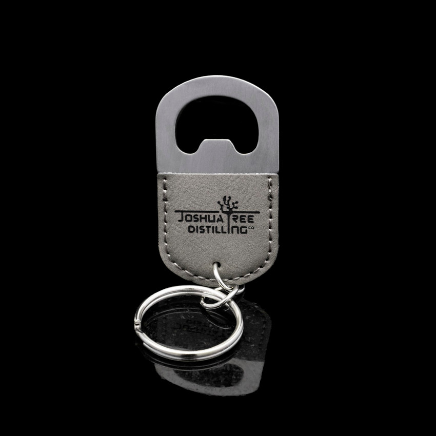 Wholesale engraved Oval Gray Keychain Bottle Opener customized with Joshua Tree Distillery logo on a black background