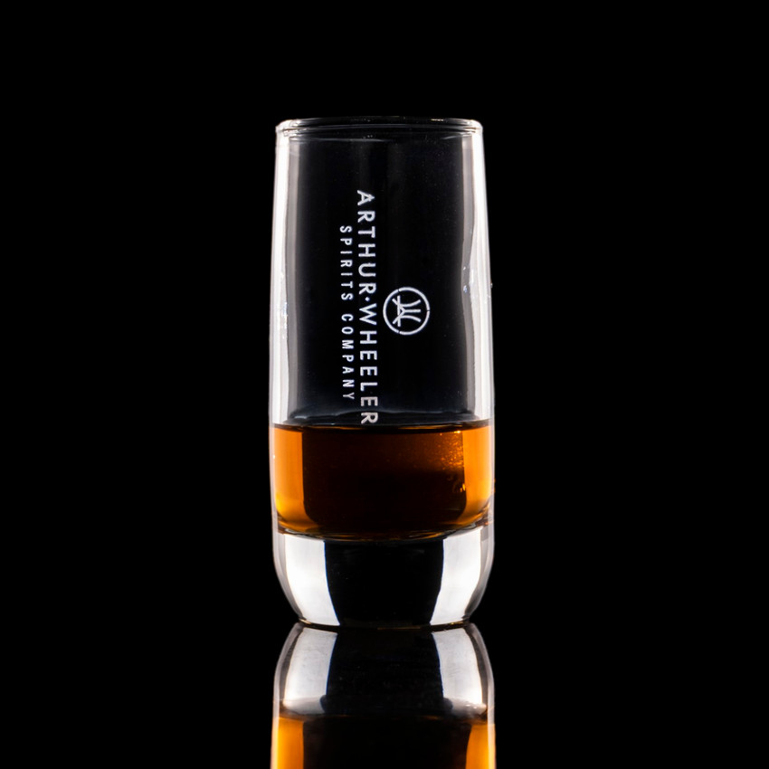 Wholesale engraved 2.5 oz. Nordic Shot Glass customized with Arthur Wheeler logo on a black background