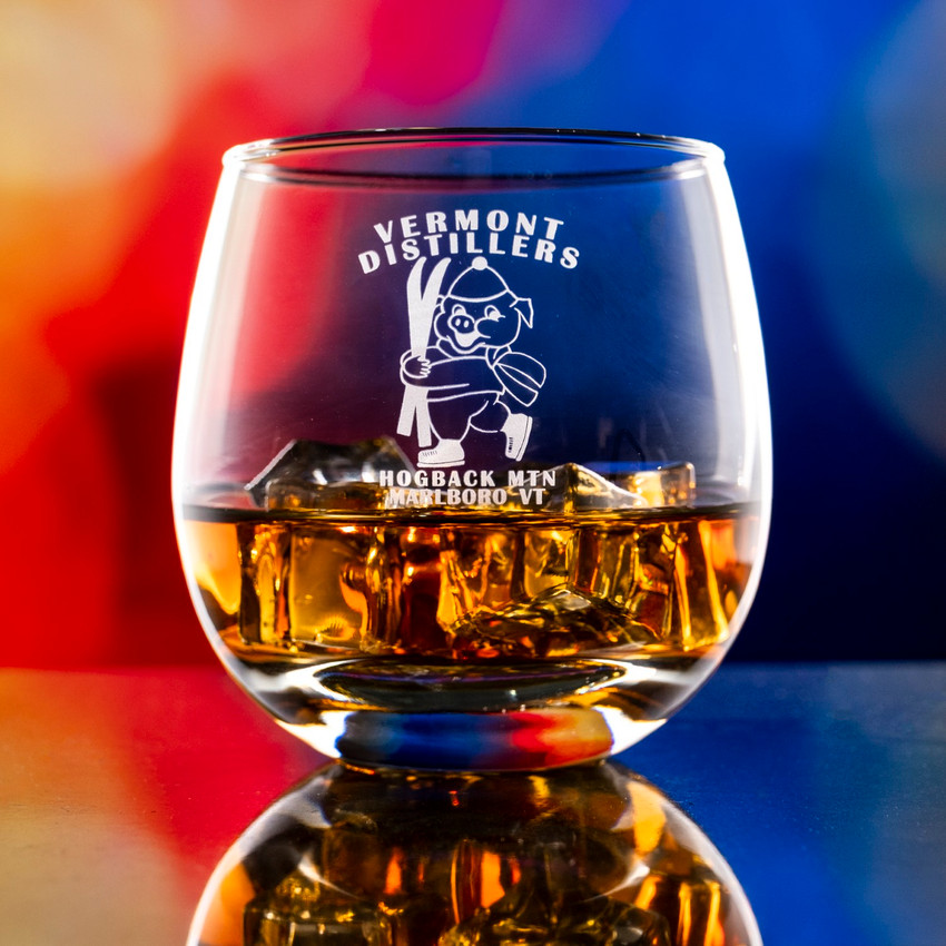 Wholesale engraved 15 oz. Hogs Head Rocks Glass customized with Vermont Distillers logo on a bokeh background