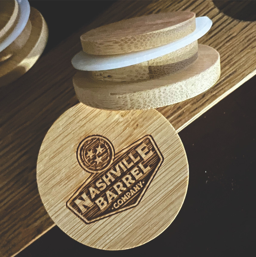 Wholesale engraved Glencairn Barrel Cap customized with Nashville Barrel Company logo on a wood background