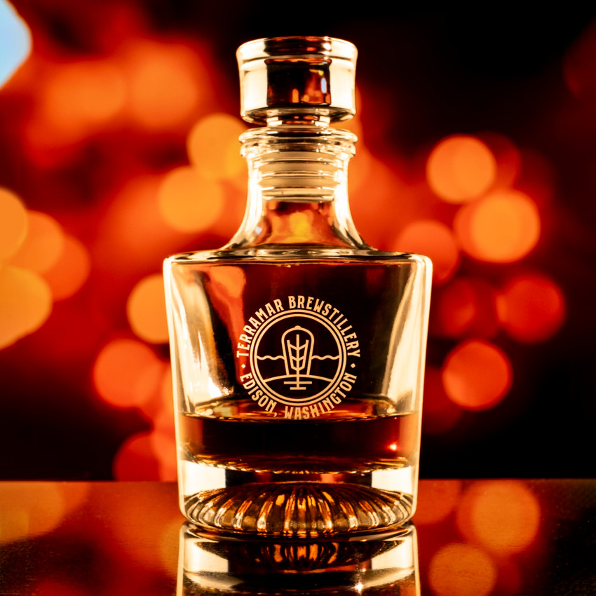 Wholesale engraved Venus Whiskey Decanter customized with Terramar Brewstillery logo on a bokeh background