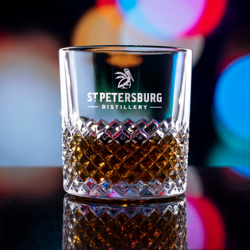 Wholesale engraved 11.5 oz. Carats Rocks Glass customized with St Petersburg Distillery logo on a bokeh background
