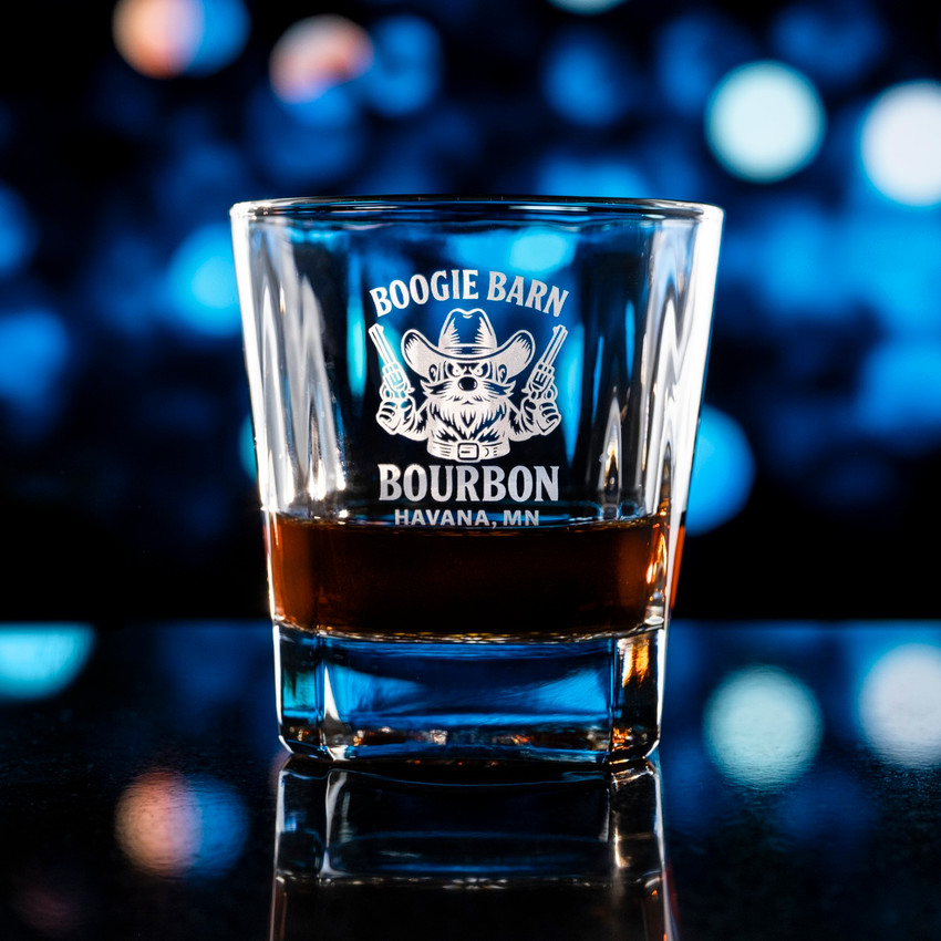 Wholesale engraved 10.5 oz Bardic Old Fashioned Rocks Glass customized with Boogie Barn Bourbon logo on a bokeh background