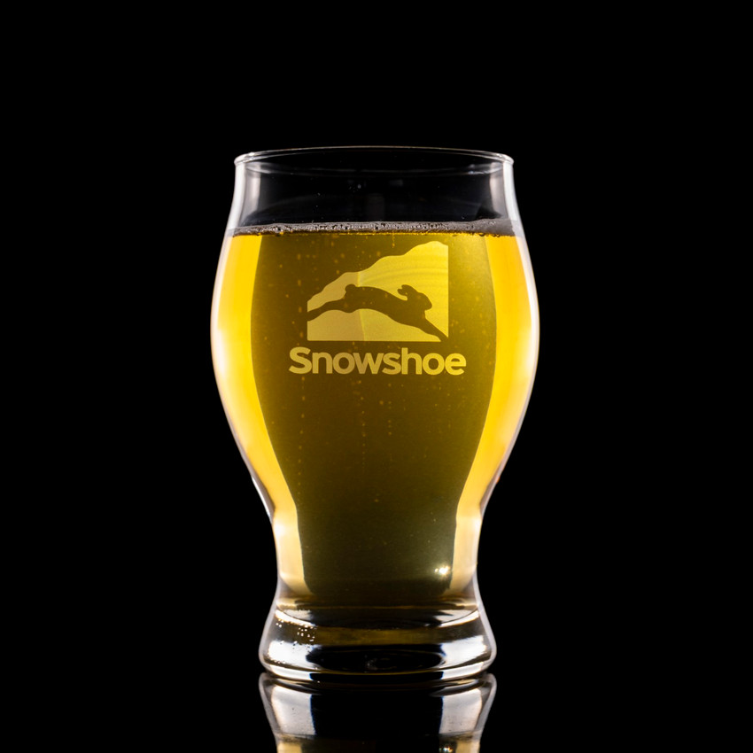 Wholesale engraved 16 oz. Barlow Pilsner Glass customized with Snowshoe Resorts logo on a black background