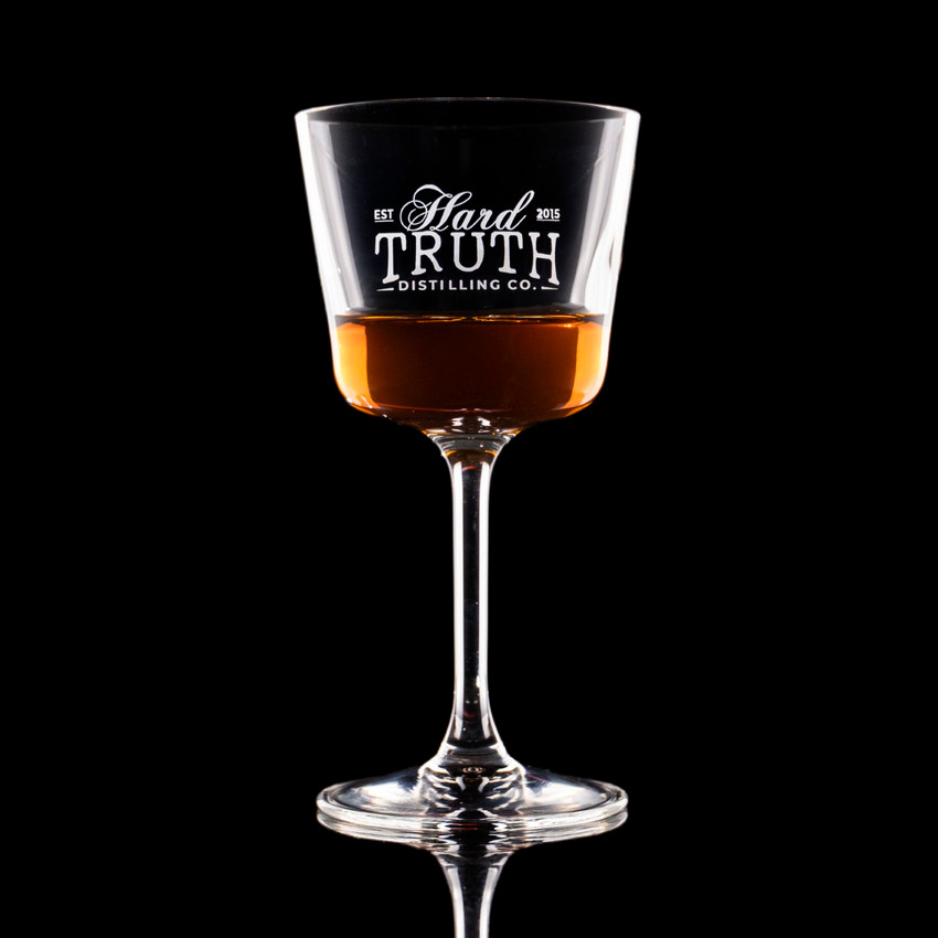 Wholesale engraved 5.5 oz. Romeo Nick & Nora Glass customized with Hard Truth Distillers logo on a black background