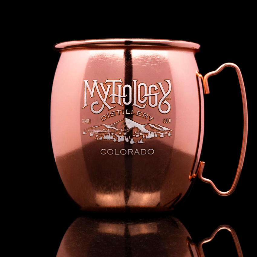 Wholesale engraved Copper Moscow Mule Mugs customized with Mythology Distillery logo on a black background