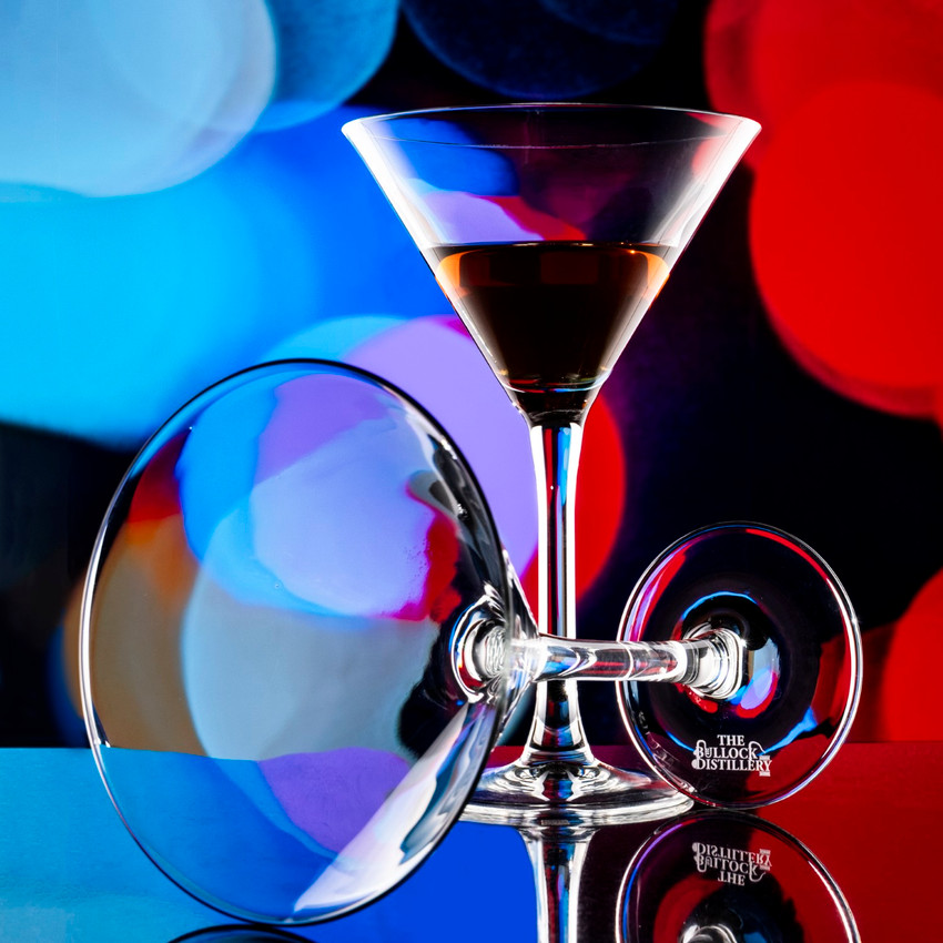 Wholesale engraved 10.5 oz. Classic Martini Glass customized with The Bullock Distillery logo on a bokeh background