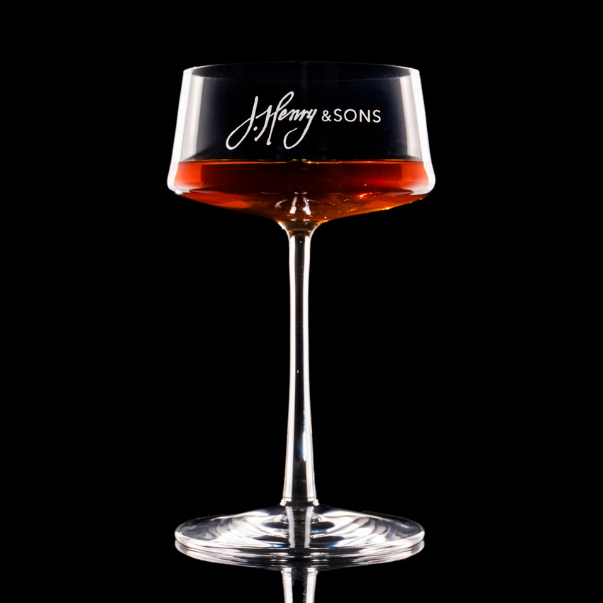 Wholesale engraved 9.25 oz. Stolzle Power Coupe customized with J Henry & Sons logo on a black background