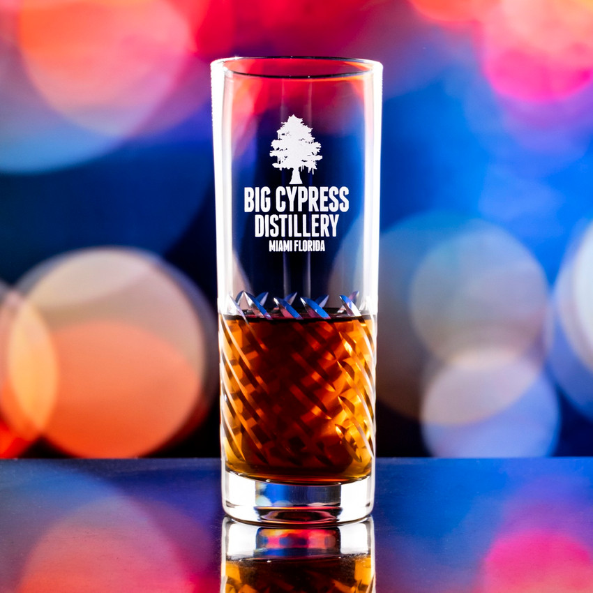 Wholesale engraved 11 oz. Luna HighBall Glass customized with Big Cypress Distillery logo on a bokeh background