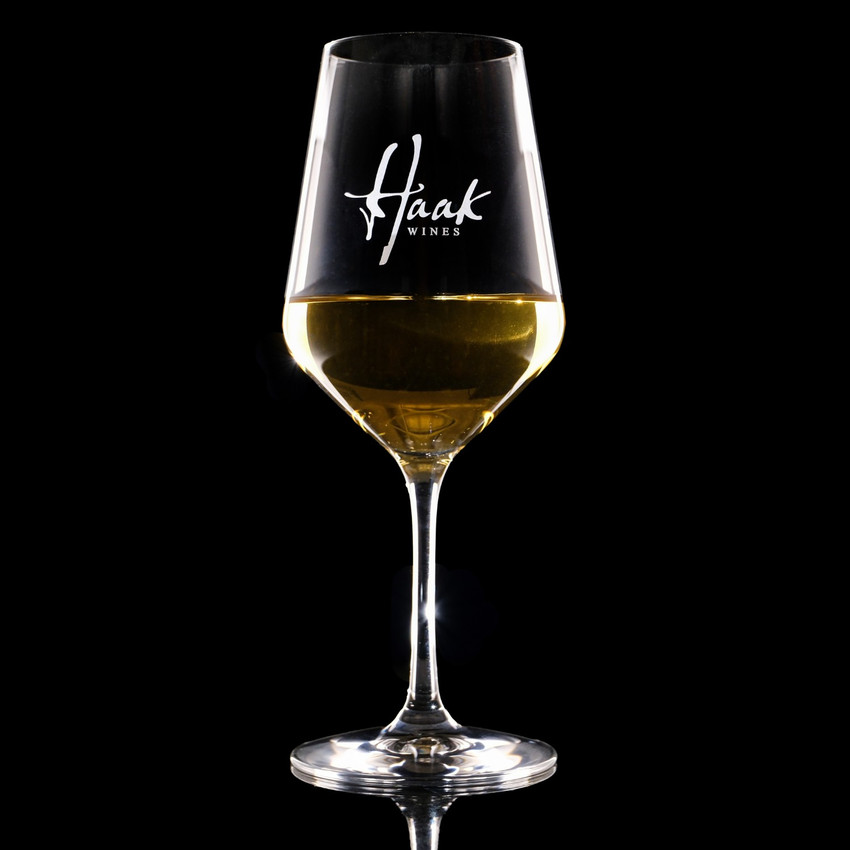 Wholesale engraved Stolzle 16.5 oz. Revolution Wine Glass customized with Haak Wines logo on a black background