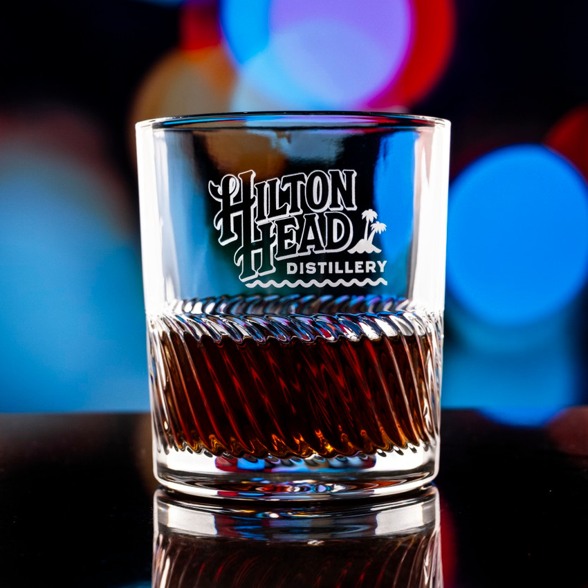 Wholesale engraved 11.5 oz. Riptide Rocks Glass customized with Hilton Head Distillery logo on a bokeh background