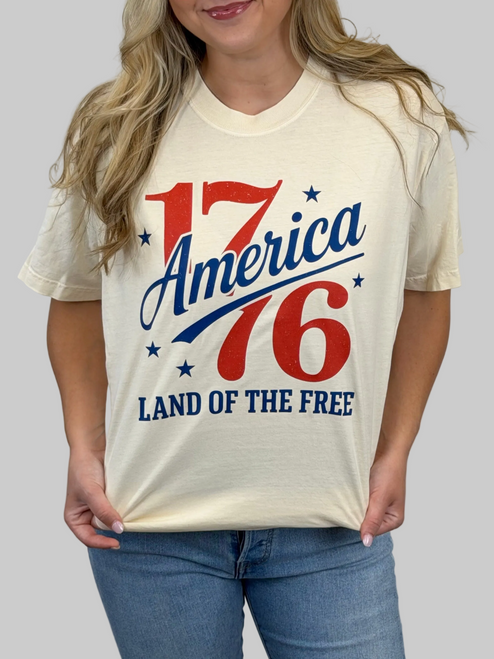 Person wearing a t-shirt with 'America 76 Land of the Free' design.