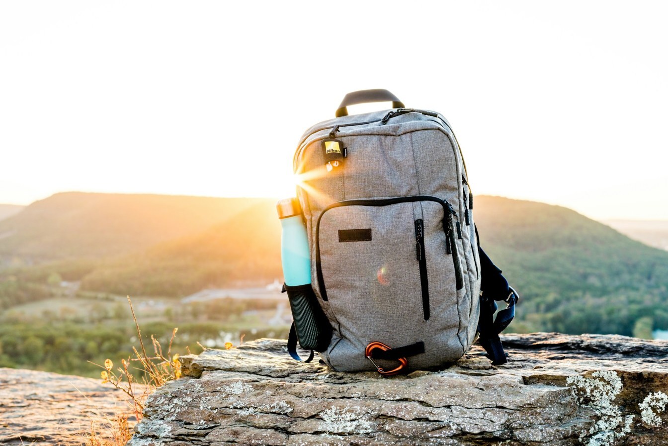 A backpack sitting on a rock at sunset