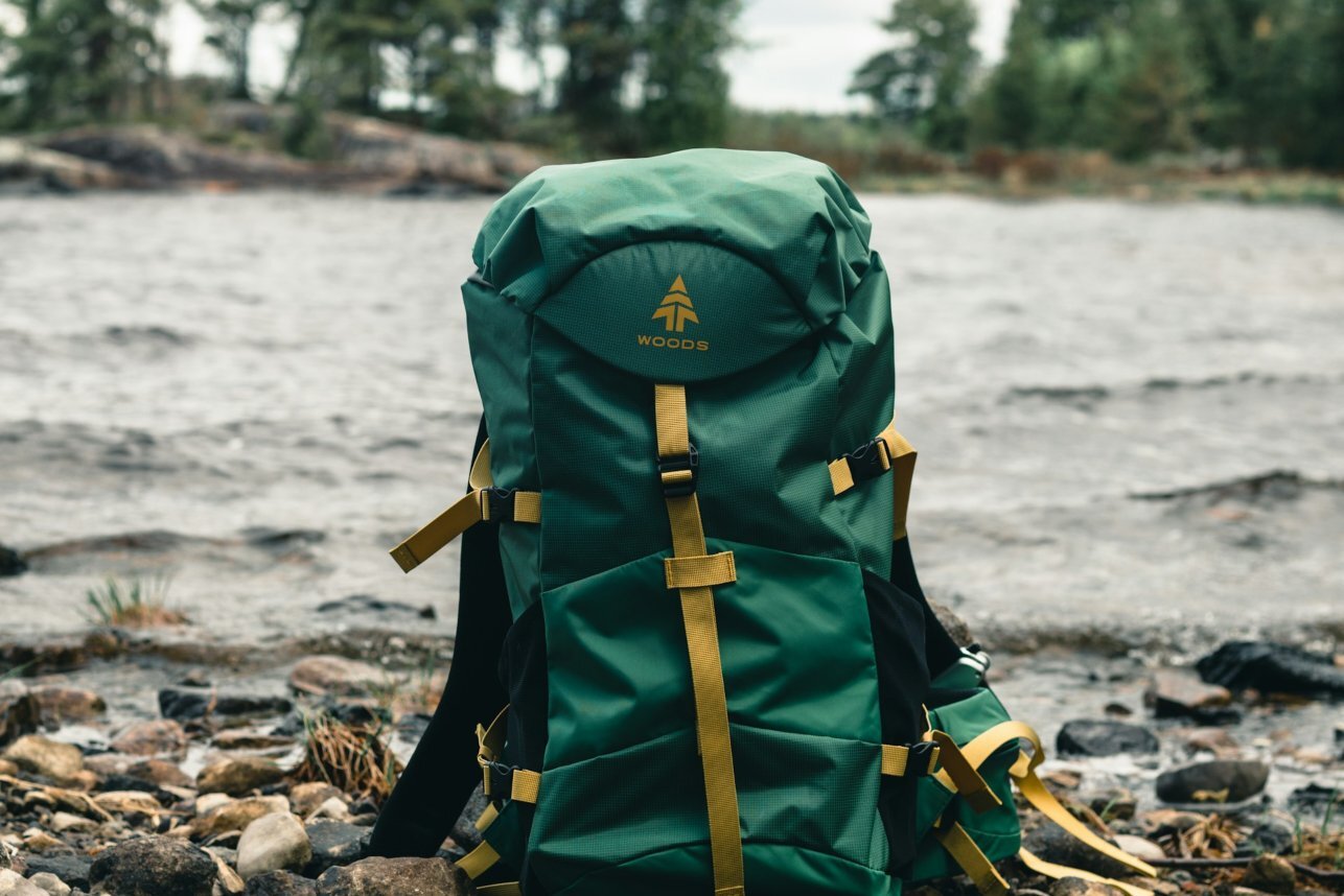 A green backpack sitting on rocks.
