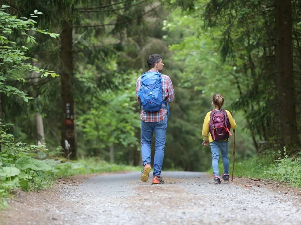 man and girl walking on dirt road